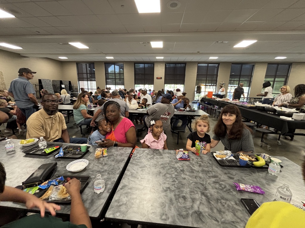 Grandparents and students smiling together during the school’s Grandparents Day Brunch. Families are gathered around tables enjoying breakfast, visiting, and celebrating time together on campus.