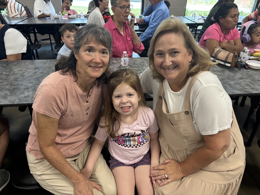 Grandparents and students smiling together during the school’s Grandparents Day Brunch. Families are gathered around tables enjoying breakfast, visiting, and celebrating time together on campus.