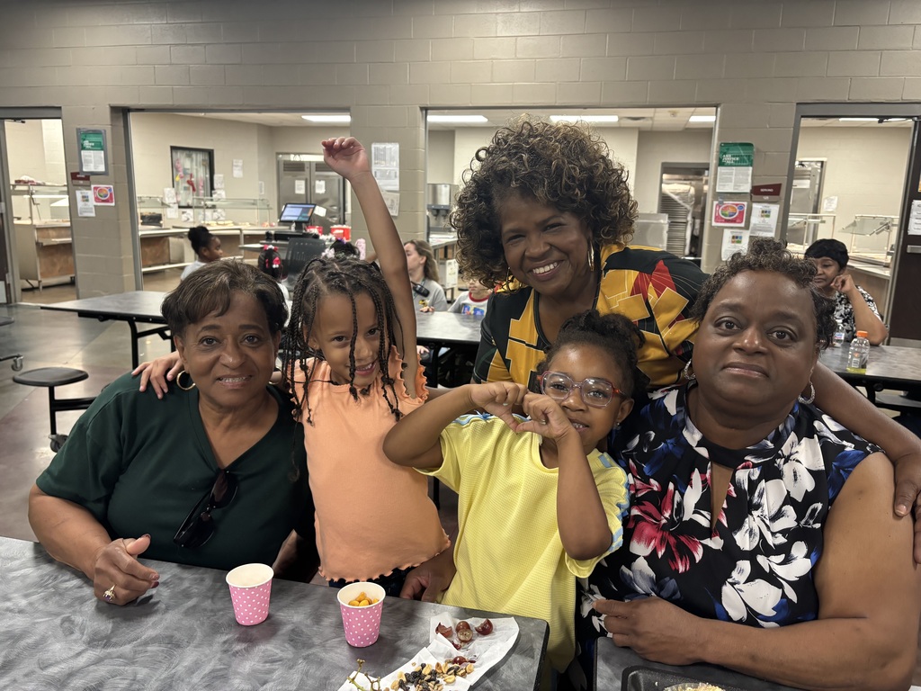 Grandparents and students smiling together during the school’s Grandparents Day Brunch. Families are gathered around tables enjoying breakfast, visiting, and celebrating time together on campus.