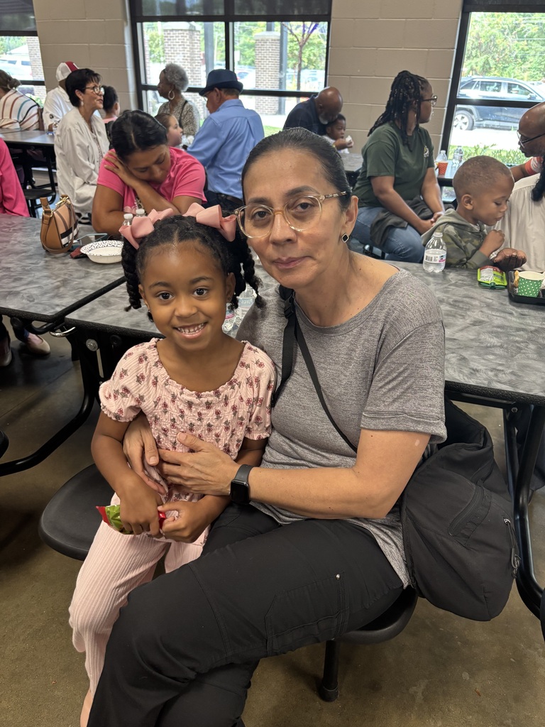 Grandparents and students smiling together during the school’s Grandparents Day Brunch. Families are gathered around tables enjoying breakfast, visiting, and celebrating time together on campus.