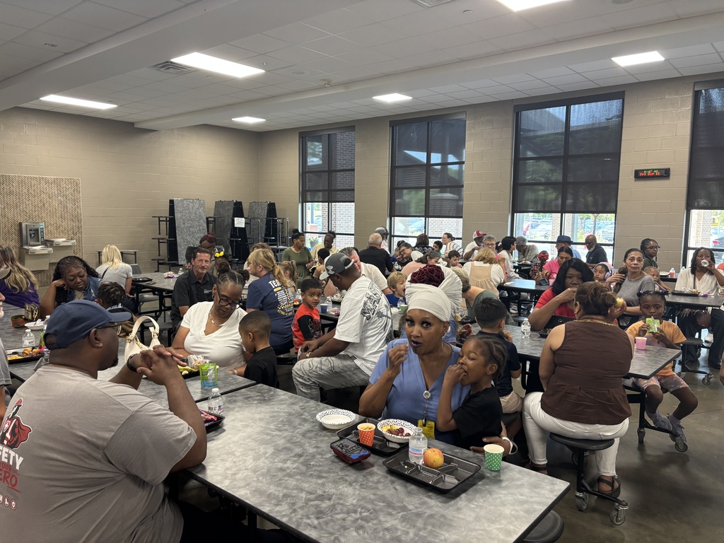 Grandparents and students smiling together during the school’s Grandparents Day Brunch. Families are gathered around tables enjoying breakfast, visiting, and celebrating time together on campus.