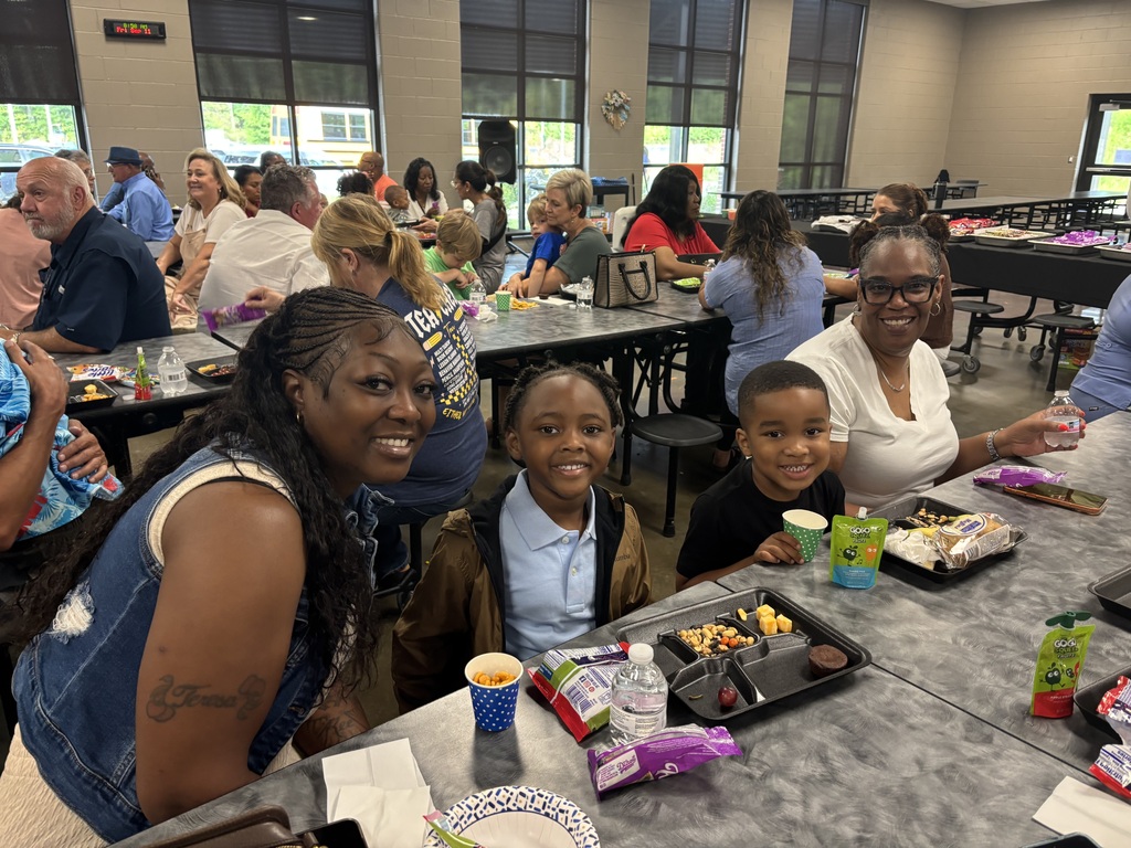 Grandparents and students smiling together during the school’s Grandparents Day Brunch. Families are gathered around tables enjoying breakfast, visiting, and celebrating time together on campus.