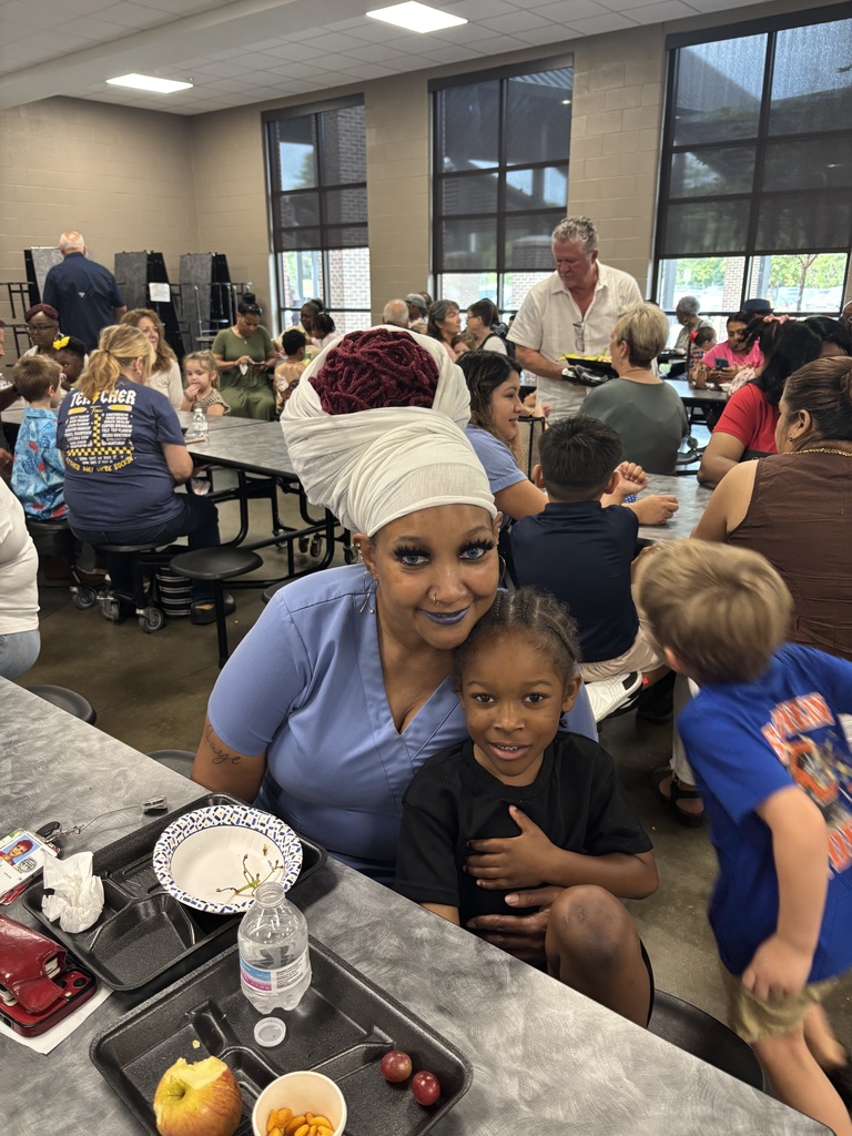Grandparents and students smiling together during the school’s Grandparents Day Brunch. Families are gathered around tables enjoying breakfast, visiting, and celebrating time together on campus.
