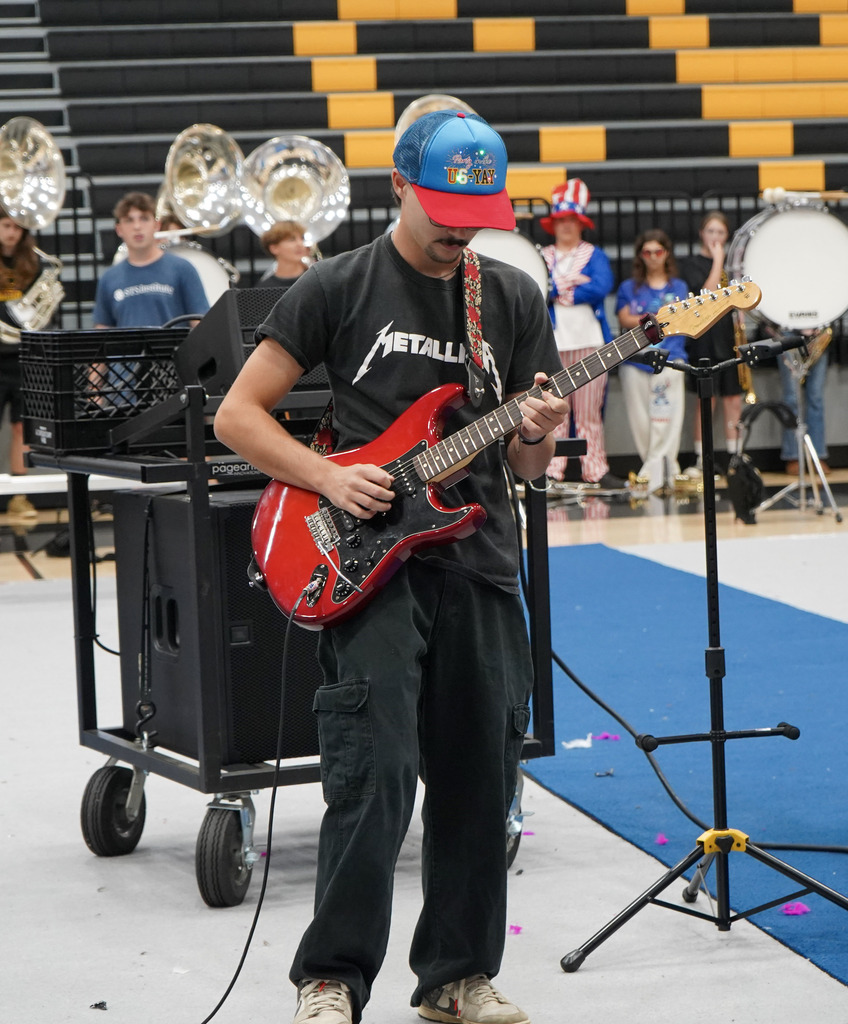 A student plays a guitar during a pep rally.
