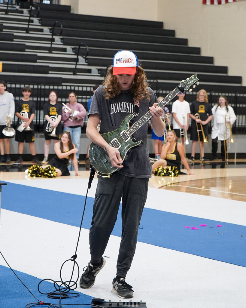 A student plays the guitar during a pep rally.