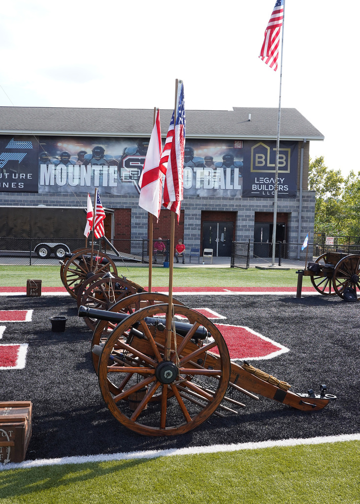 Cannons line a football field during a 9/11 remembrance ceremony.