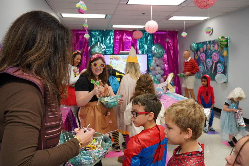 Students dressed up for Halloween and getting candy.