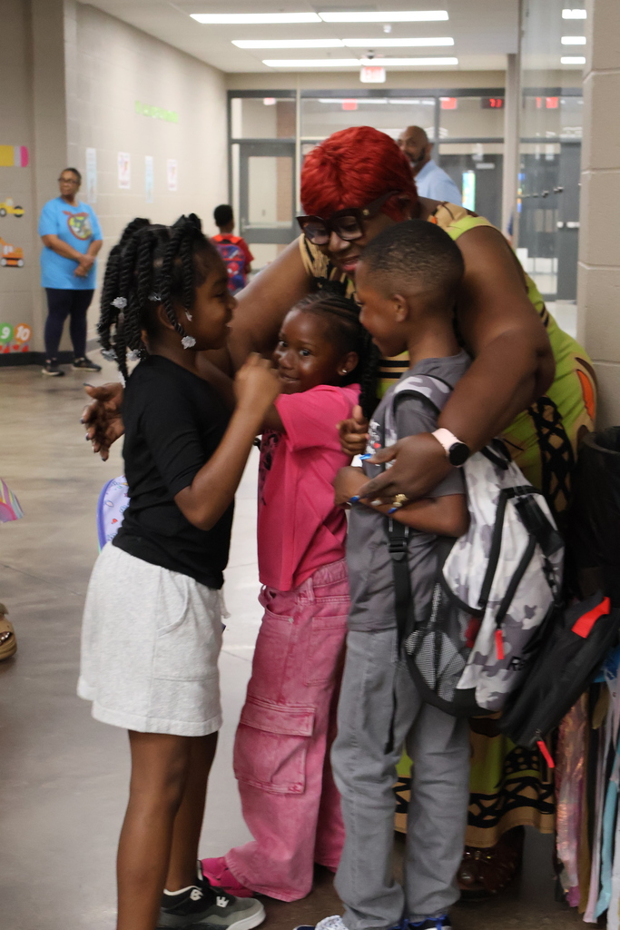 Grandparent hugging students in the school lobby