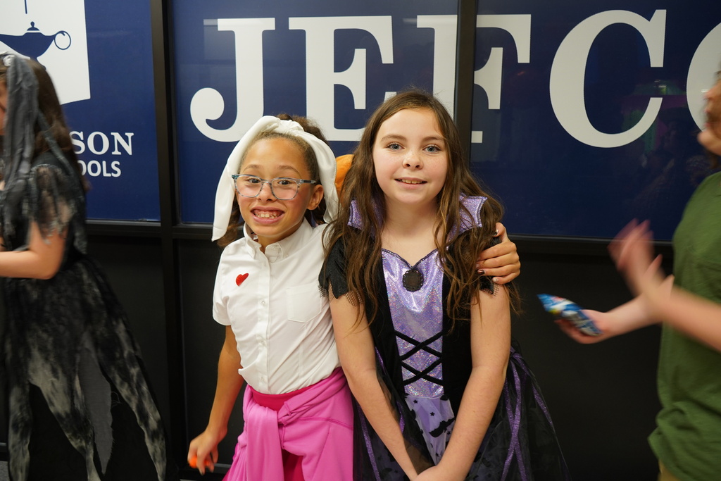 Students posing together in front of a JefCoEd sign in their halloween costumes. 