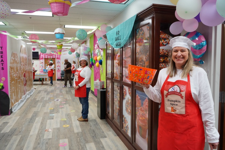 people standing in hallway in apron costume ready to hand out candy