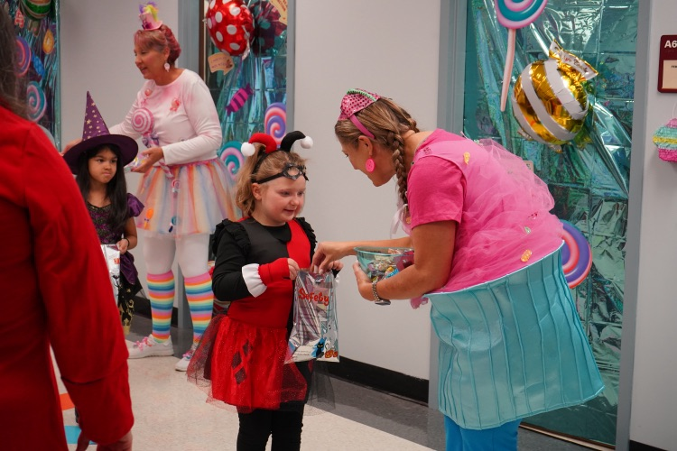 child trick or treating with an adult on her level