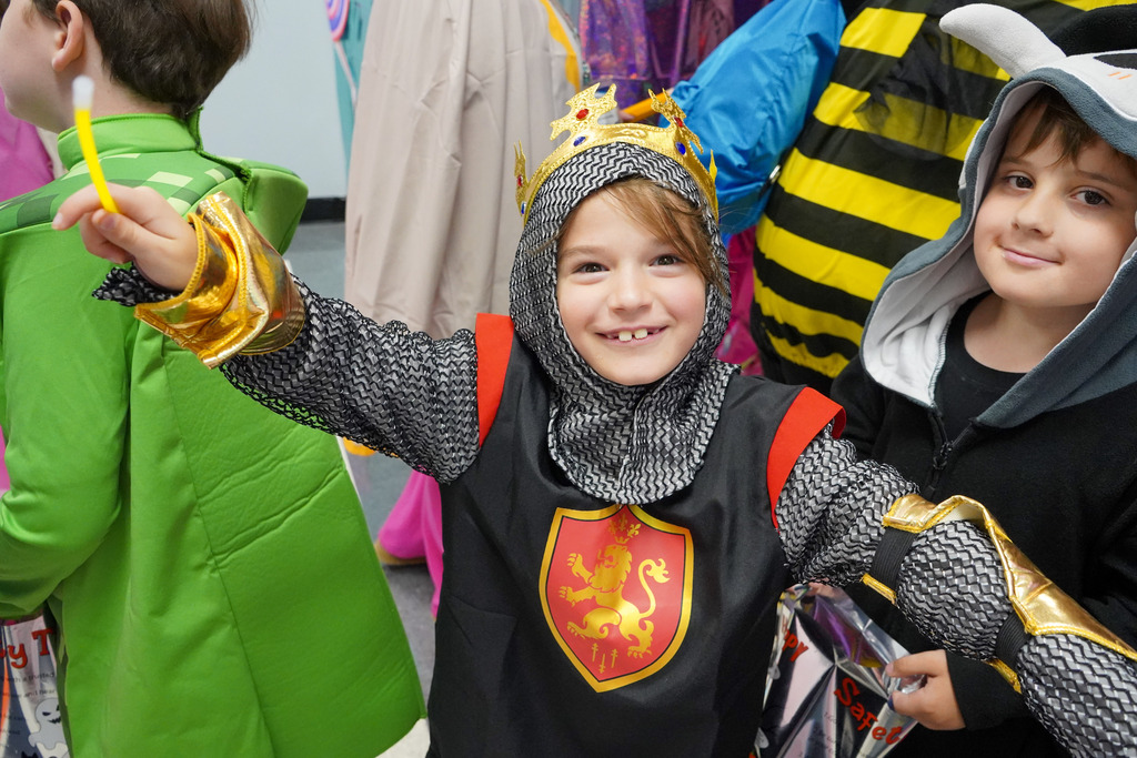 A student wearing a costume smiles for a photo.