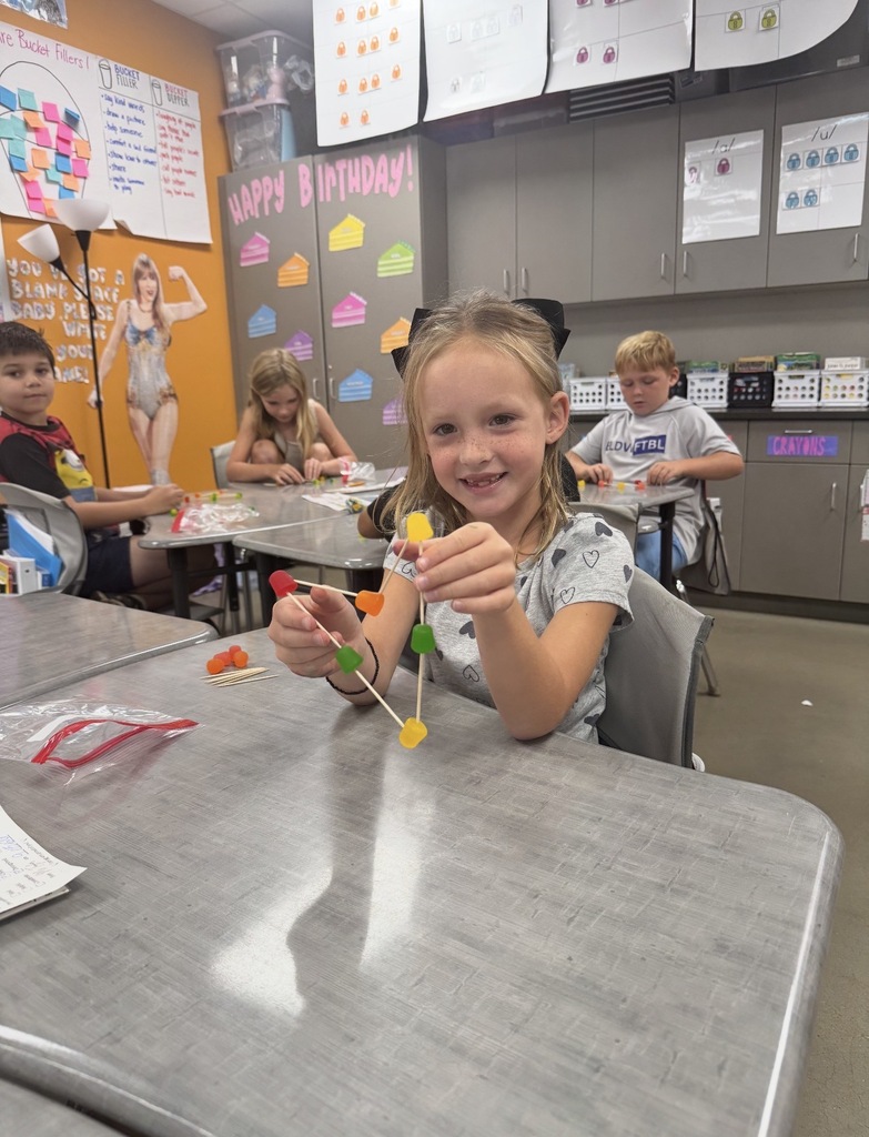 Student sitting at their desk creating a shape using dot candy and tooth picks.