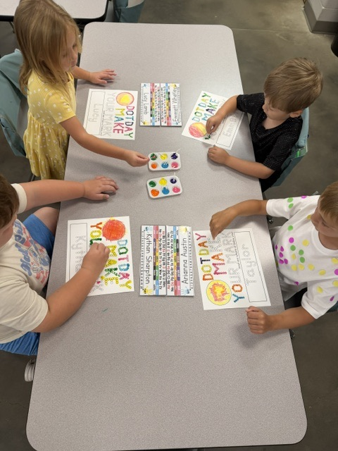 students painting a page that says “make your mark” with q tips