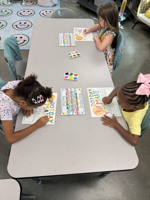 students painting a page that says “make your mark” with q tips
