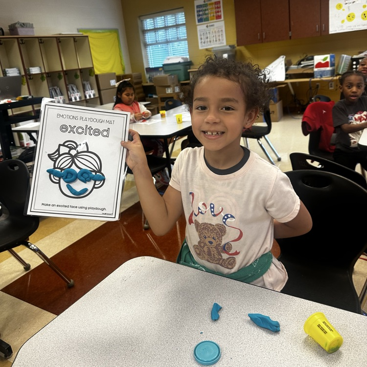 student showing their craft of a girl with a smiling face