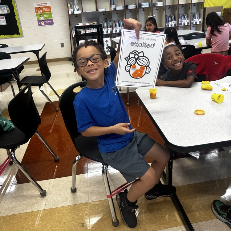 teacher helping students complete a class project about emotions