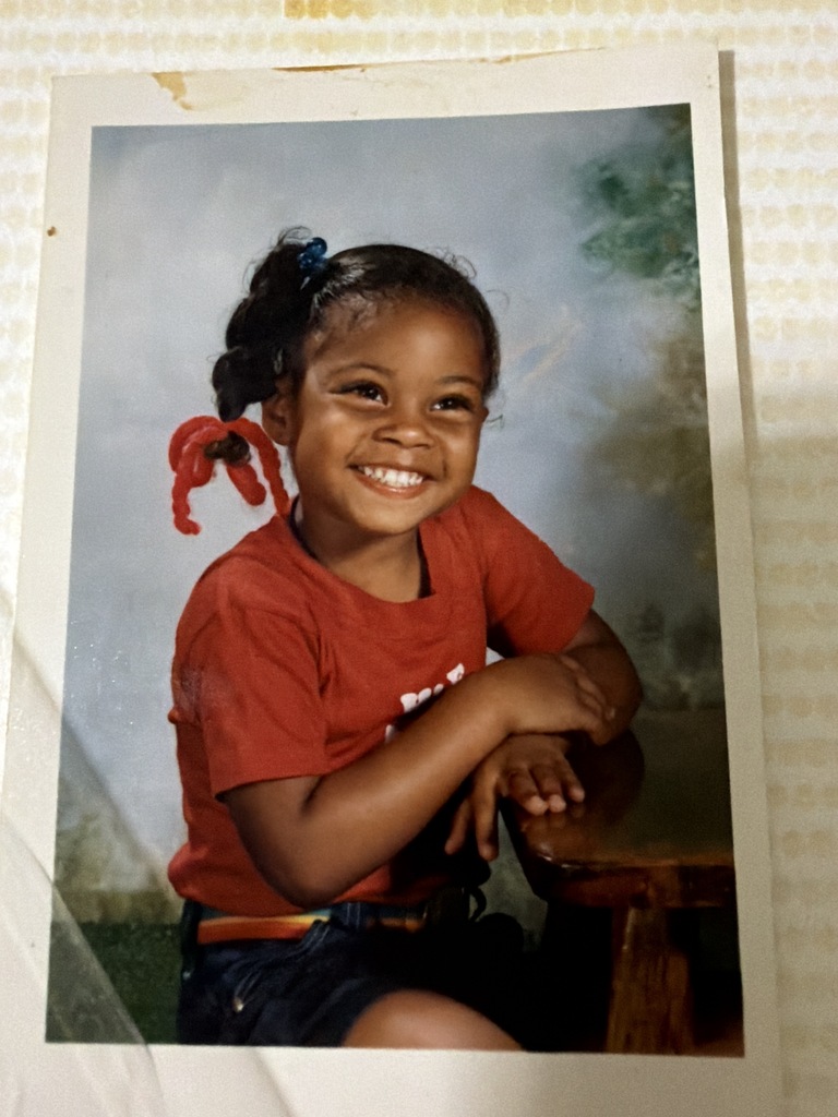 A childhood school portrait of a McCalla Elementary teacher or staff member, shared as part of a fun Picture Day guessing game for families.