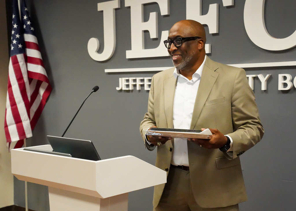 Mr. Bobby Jackson stands at a podium and accepts an award during his retirement party.