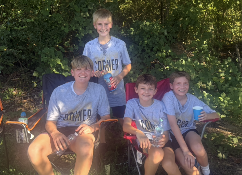 four male cross country runners outside after a race
