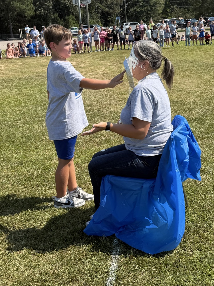 a child giving Dr. Wilson a pie in the face