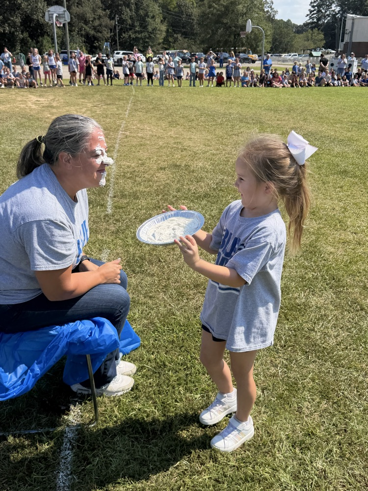 a child giving Dr. Wilson a pie in the face