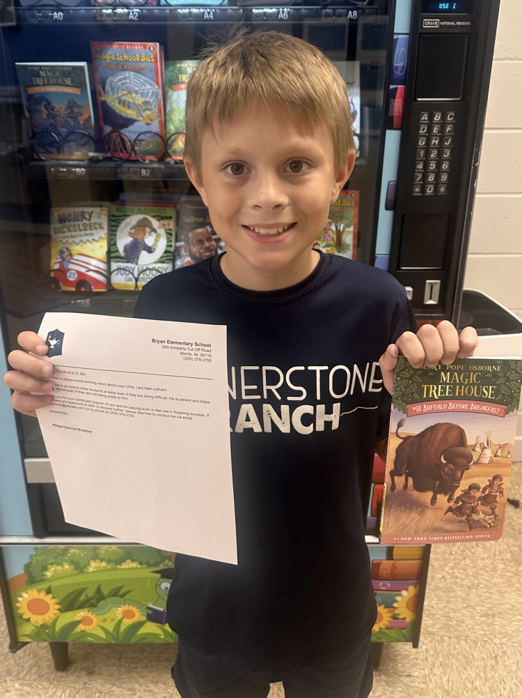 5th grade boy smiling with book and letter