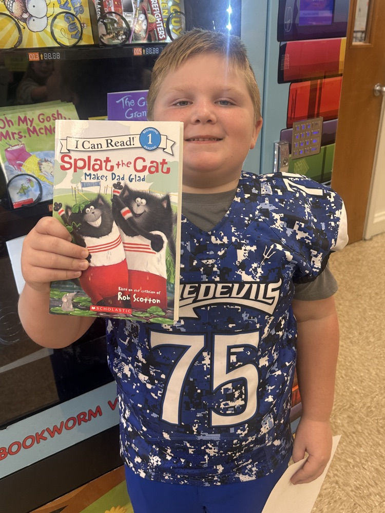 boy smiling with a book