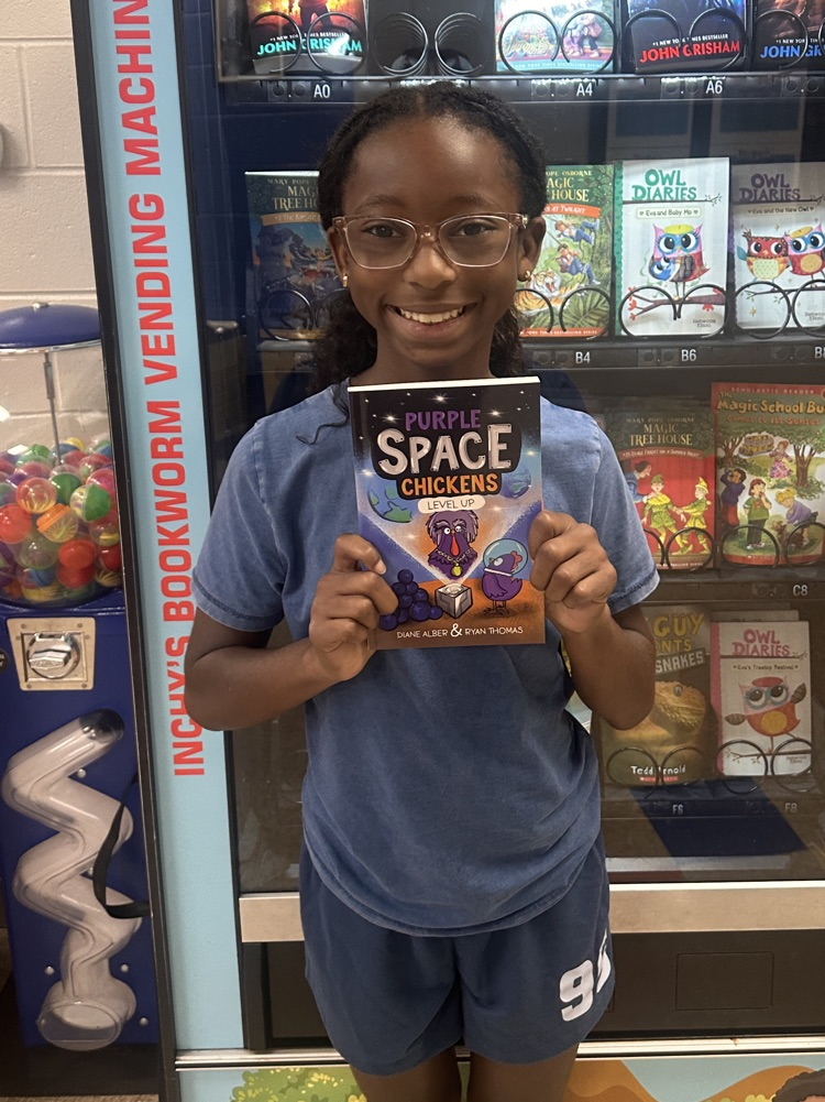5th grade girl smiling with a book