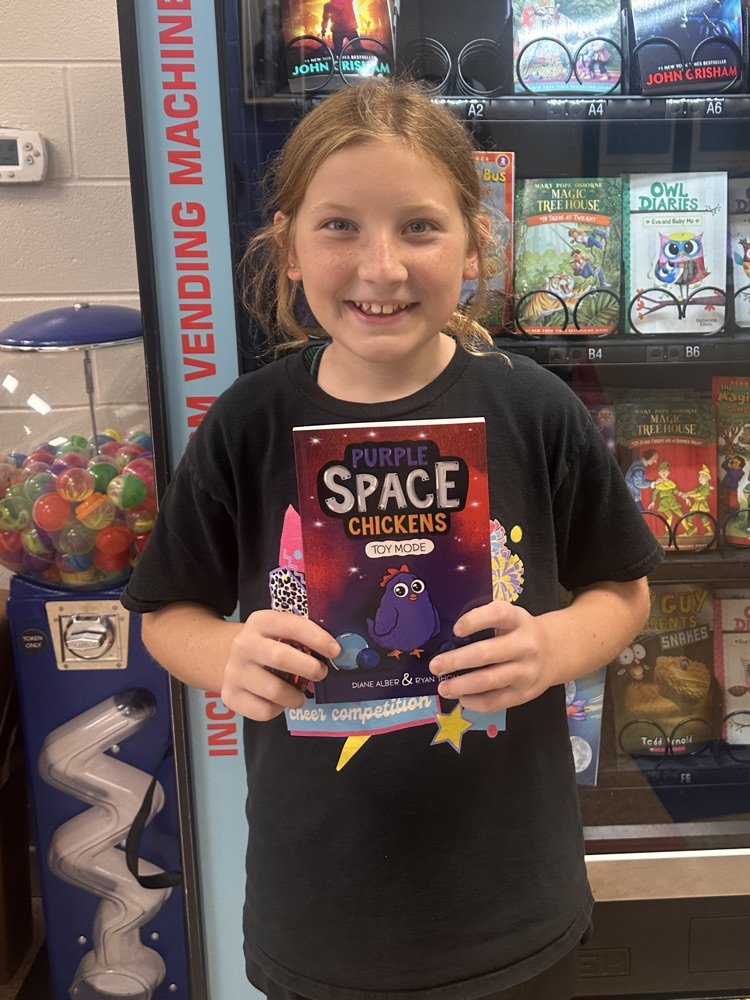 5th grade girl smiling with a book