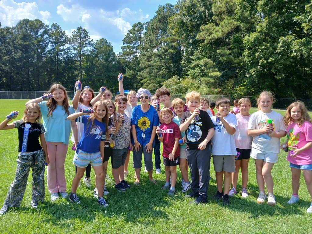 Class of 5th graders holding silly string about to spray the teacher