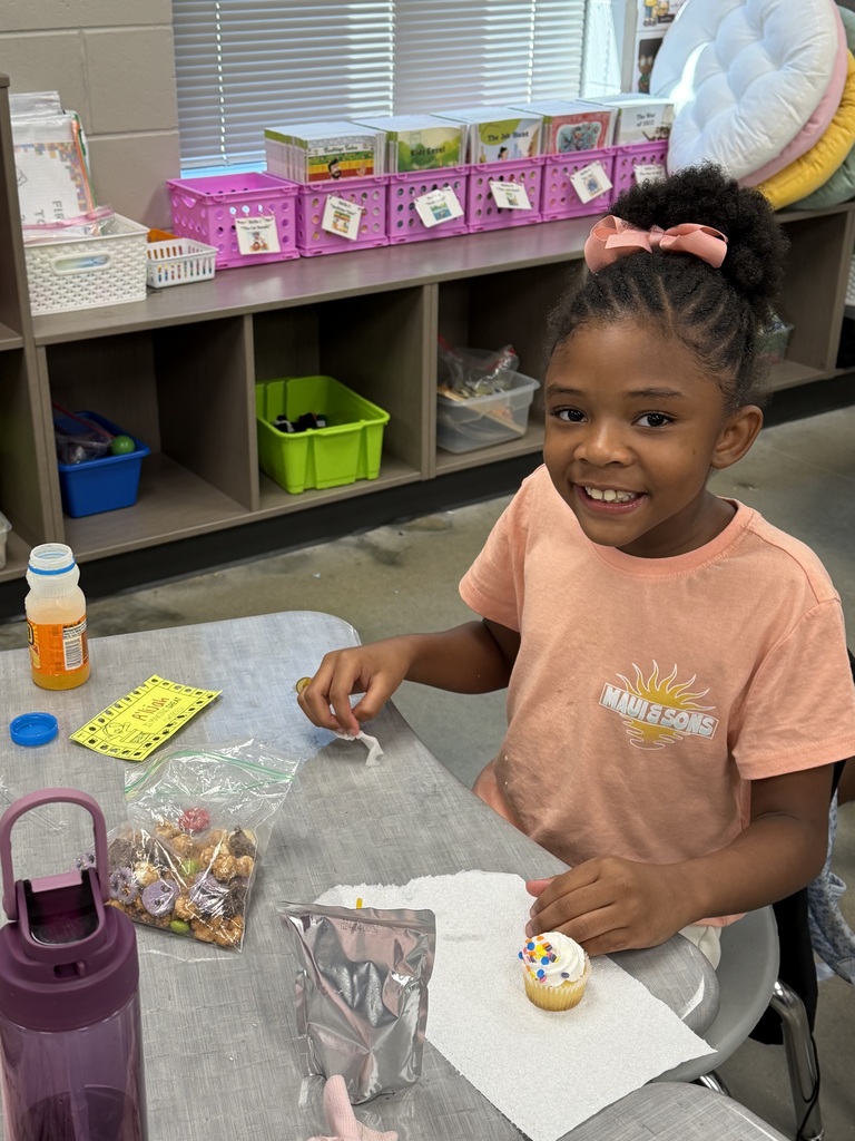 A student smiling with the bag of snack mix they made with their class