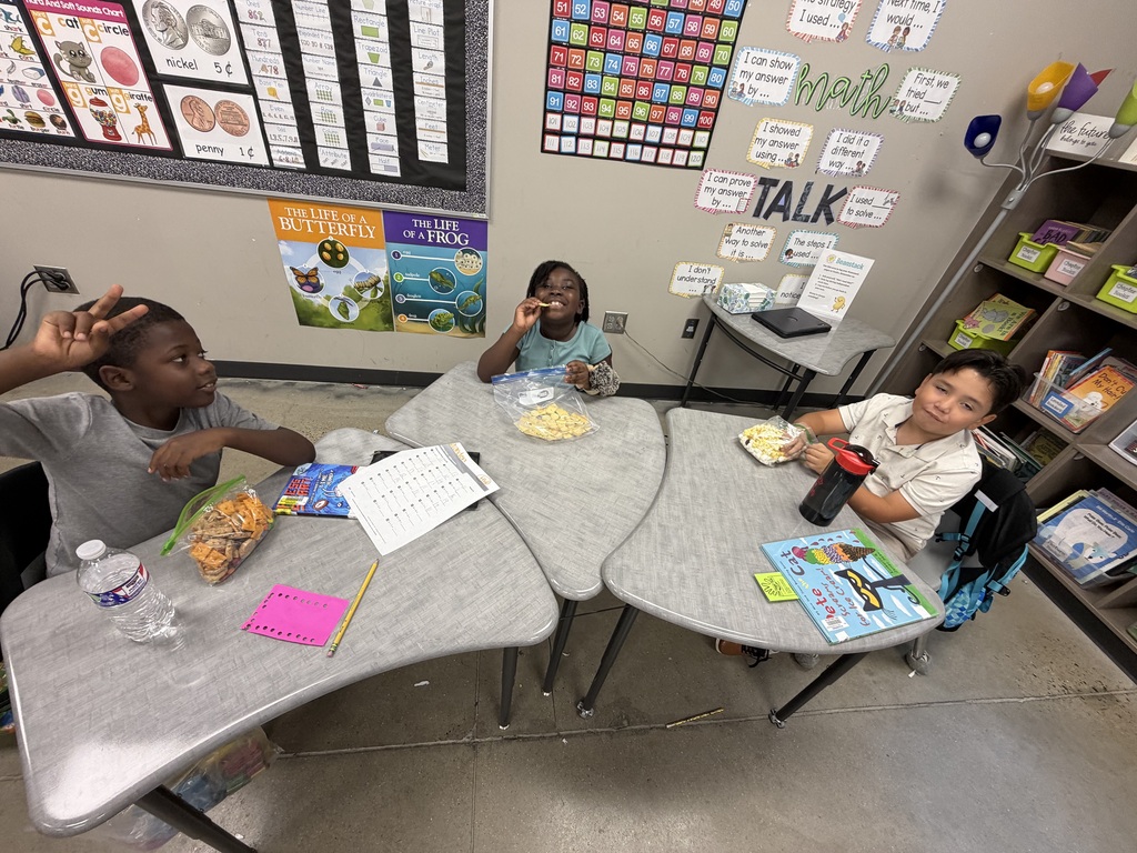 A student smiling with the bag of snack mix they made with their class