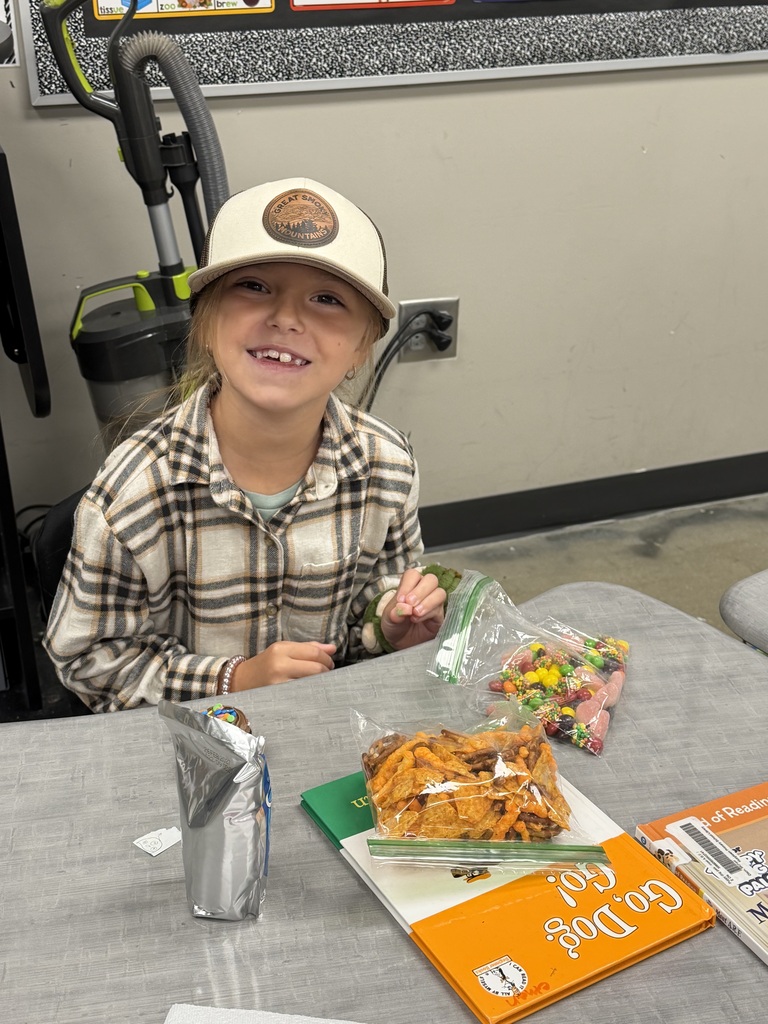 A student smiling with the bag of snack mix they made with their class