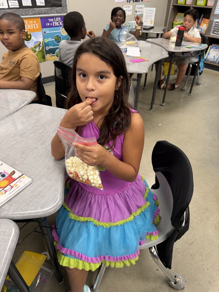 A student smiling with the bag of snack mix they made with their class