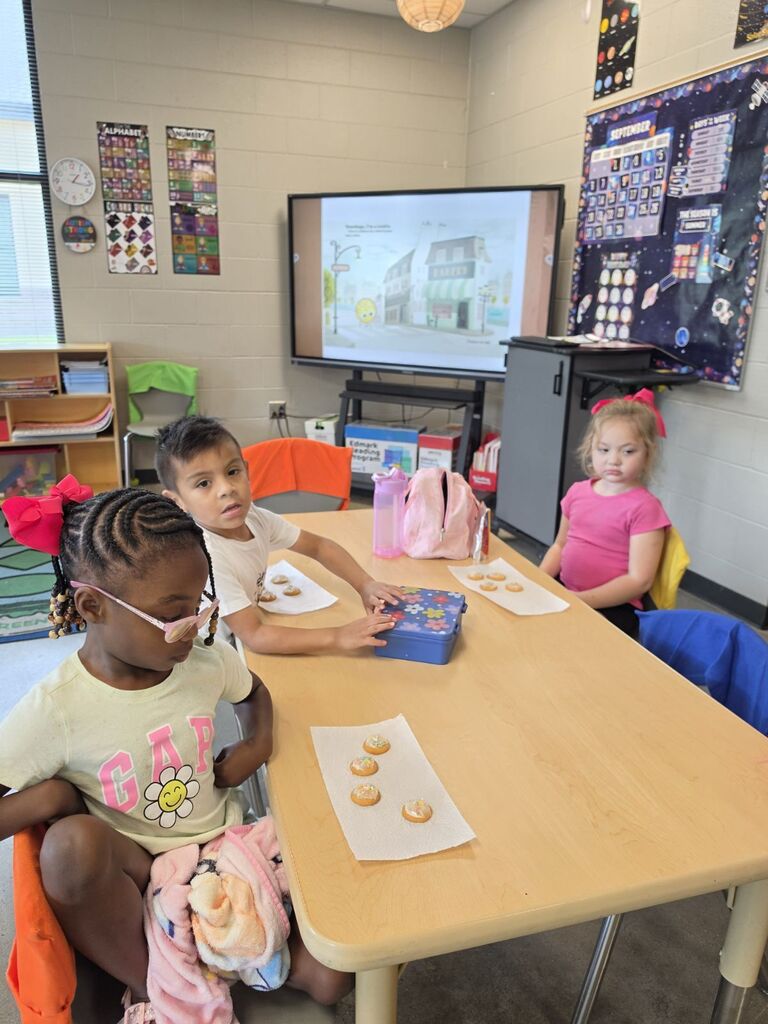 students smiling with cookies they made in class