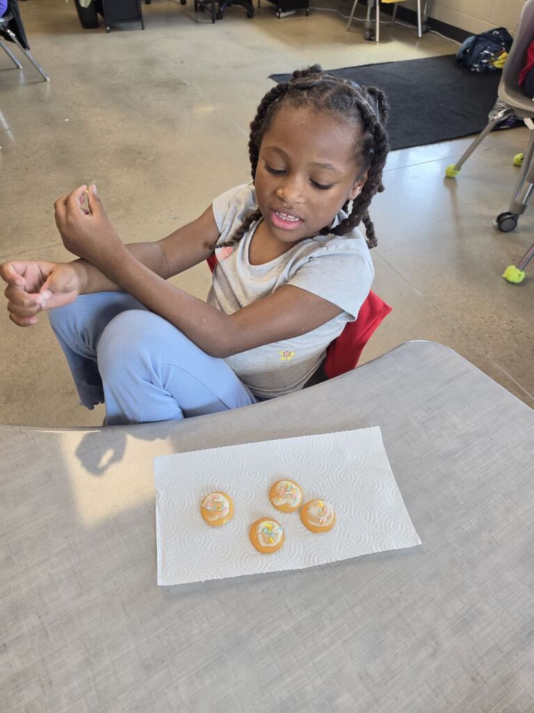 students smiling with cookies they made in class