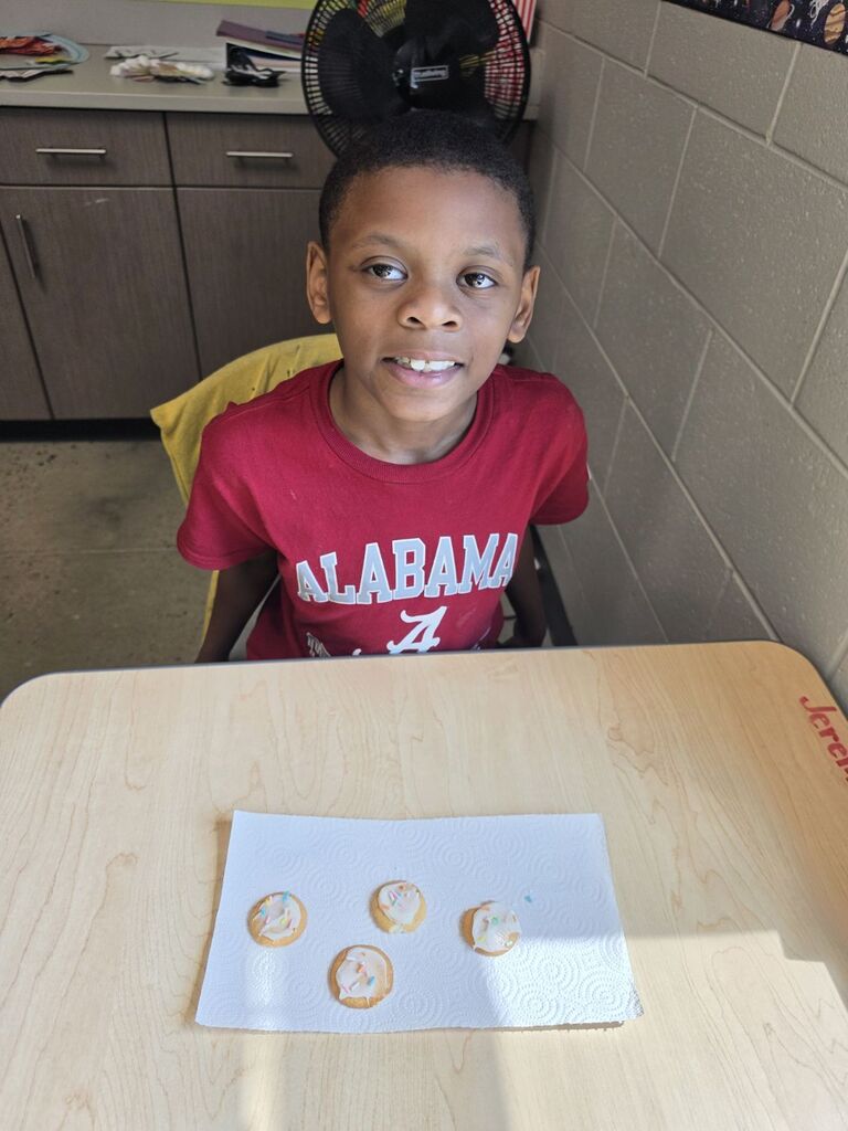 students smiling with cookies they made in class