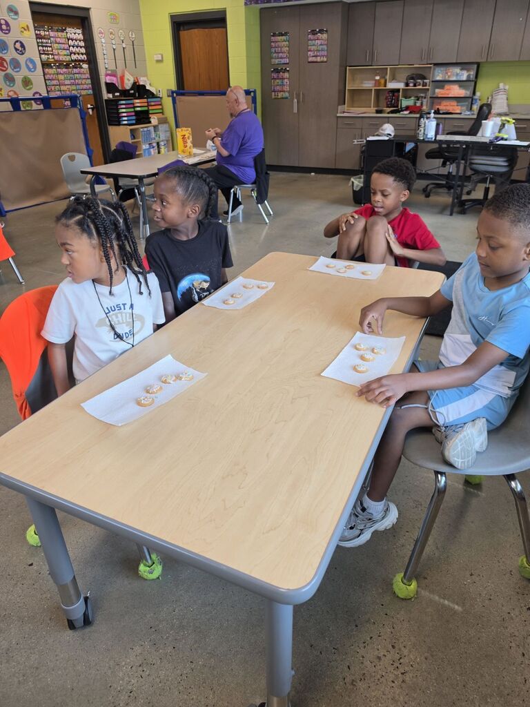 students smiling with cookies they made in class