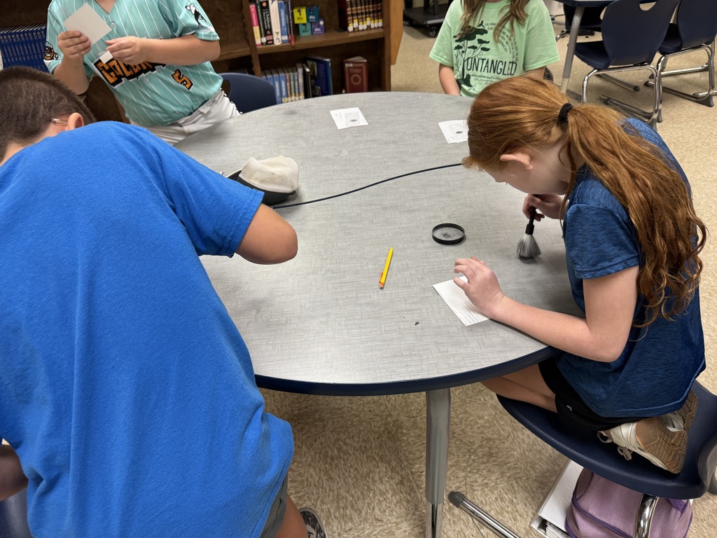 students in a library at a table working on a project