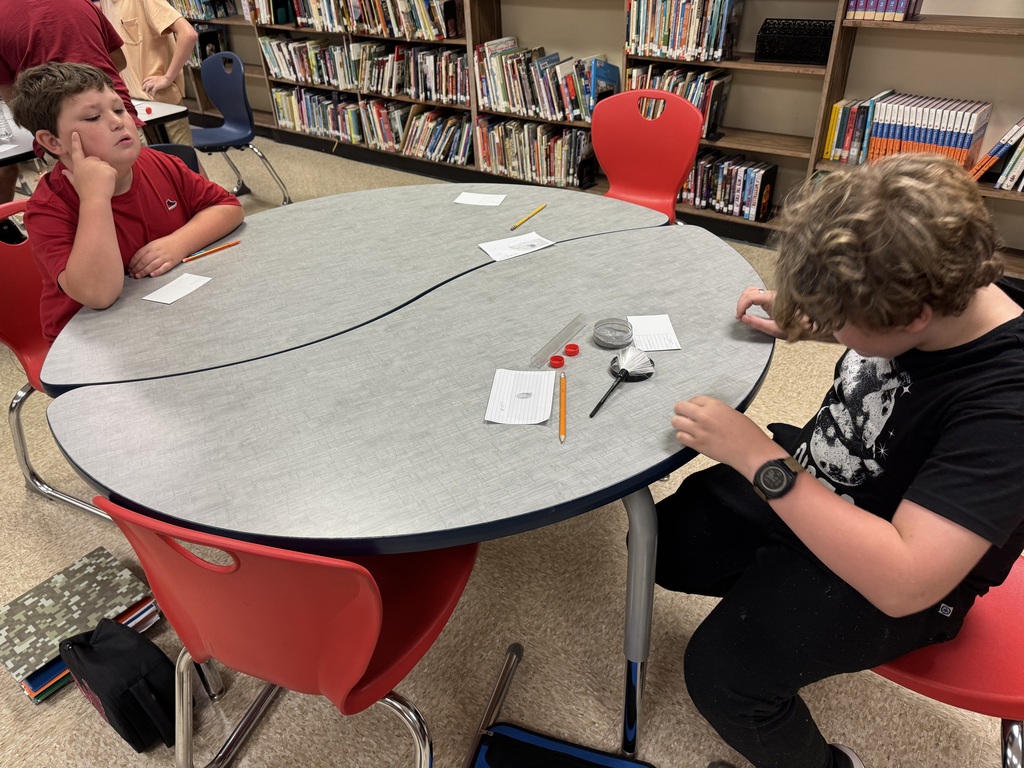 students in a library at a table working on a project