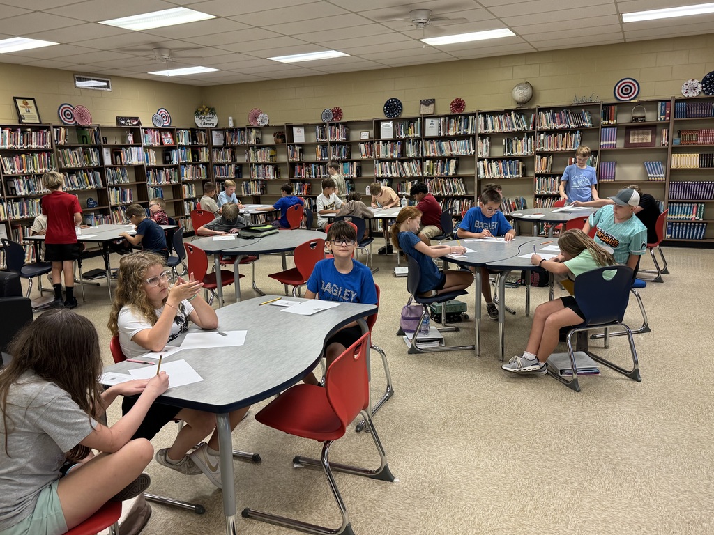 students in a library at a table working on a project