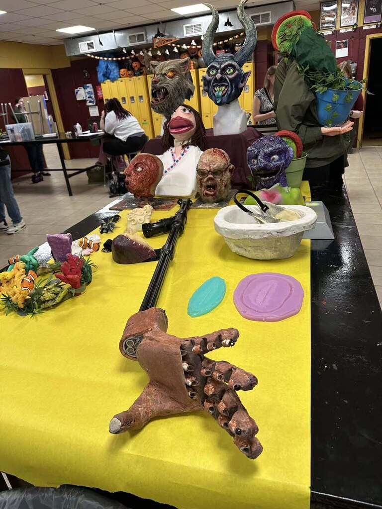 Hand-made props line a table in a special effects classroom.