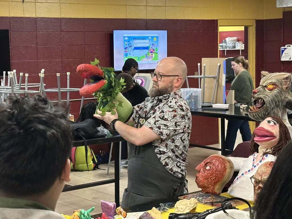 Pinson Valley High School's Special Effects teacher shows students a puppet while standing in his classroom.