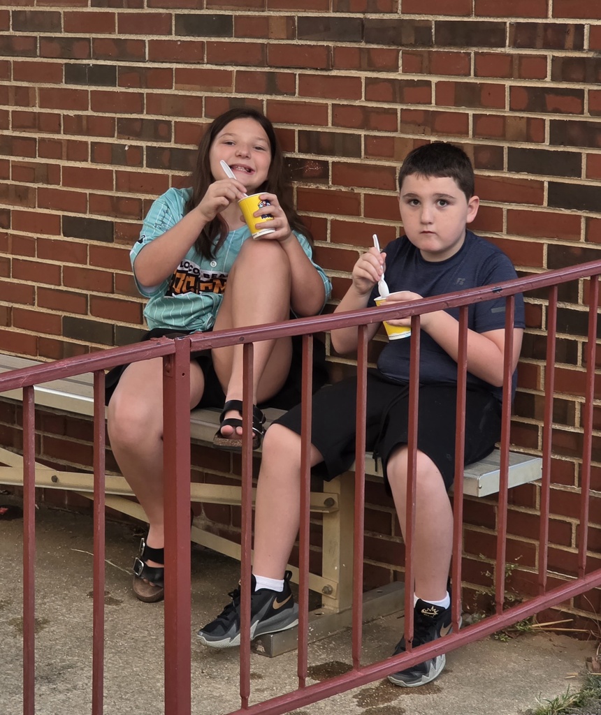 2 students sitting and eating Kona Ice