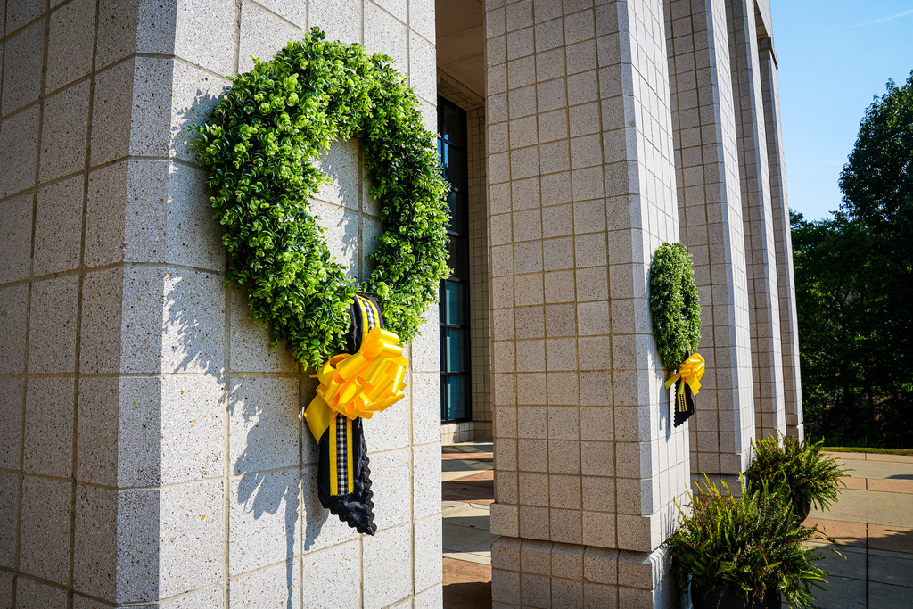 Wreaths with yellow ribbons hang outside a school.