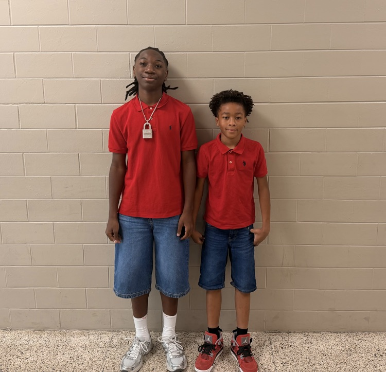Two HMS students pose together in matching red polo shirts and denim for Two to Tango Day.