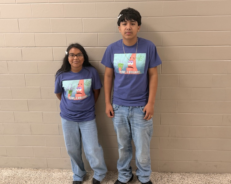 Two HMS students pose in matching purple graphic shirts and jeans for Two to Tango Day.