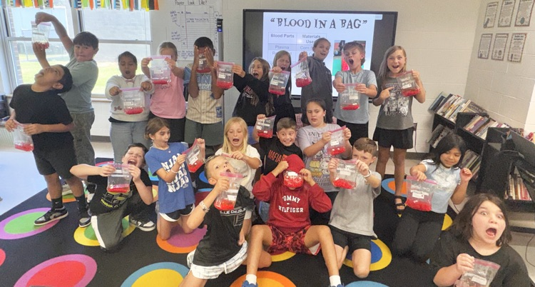 4th graders posing with their blood bags