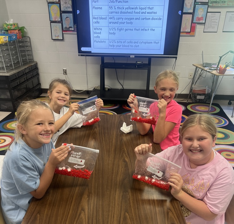 4th grade girls at their table posing with blood bags